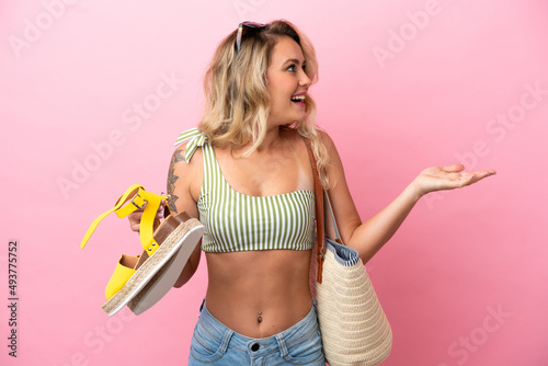 Young Brazilian woman in swimsuit in summer holidays isolated on pink background with surprise facial expression