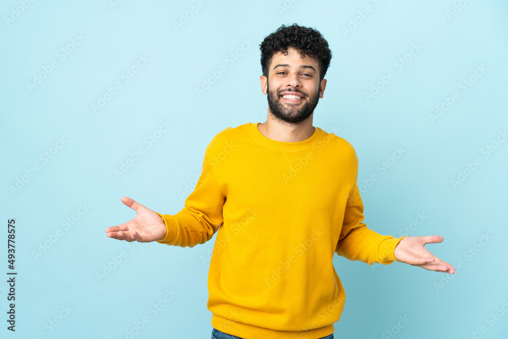 Young Moroccan man isolated on blue background happy and smiling Young Moroccan man isolated on blue background happy and smiling