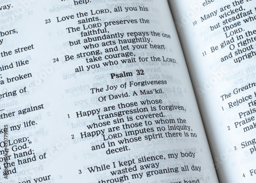 Psalm 32, the joy of forgiveness verses, open Holy Bible Book. A closeup. The Christian biblical concept of salvation and joy in God Jesus Christ.