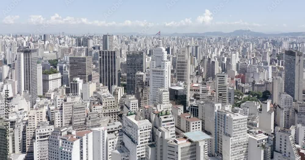side drone flight over downtown Sao Paulo, state flag fluttering on top of a building, blue sky, Sao Paulo, Brazil side drone flight over downtown Sao Paulo, state flag fluttering on top of a building, blue sky, Sao Paulo, Brazil