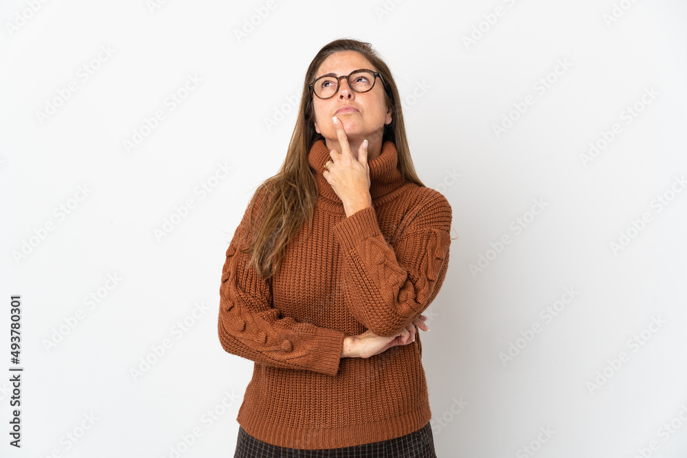 Middle age Brazilian woman isolated on white background having doubts while looking up Middle age Brazilian woman isolated on white background having doubts while looking up