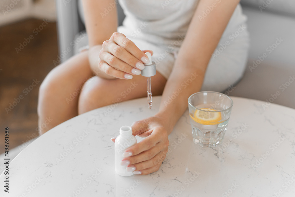 Woman puts the face serum on her hands. Close up of the bottle. Home skin care. Woman puts the face serum on her hands. Close up of the bottle. Home skin care.