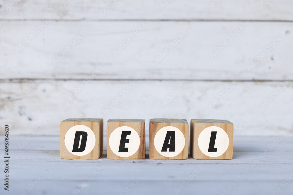 deal concept written on wooden cubes or blocks, on white wooden background. deal concept written on wooden cubes or blocks, on white wooden background.