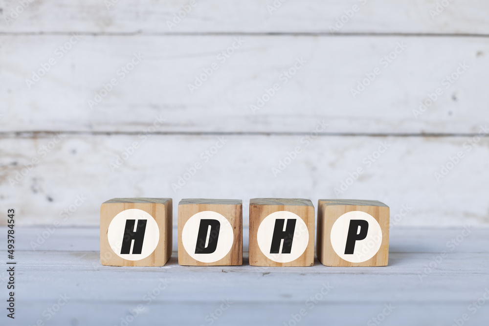 HDHP concept written on wooden cubes or blocks, on white wooden background. HDHP concept written on wooden cubes or blocks, on white wooden background.