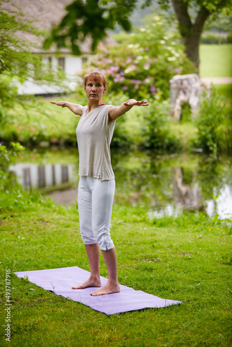 Meditating in nature. Shot of a woman doing yoga in the park.