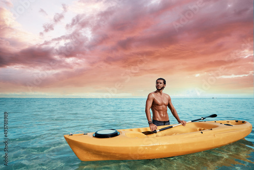 Hobby and vacation. Young man with the sea kayak  standing in water on ocean bay. © luengo_ua