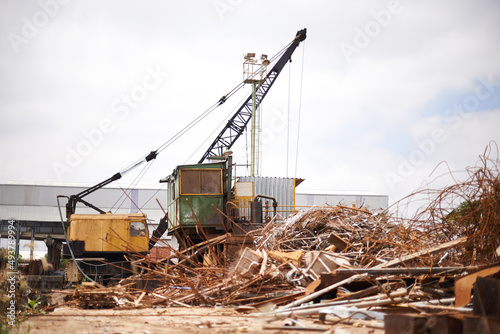 Its dirty work. Shot of a crane at work in a dumpsite.