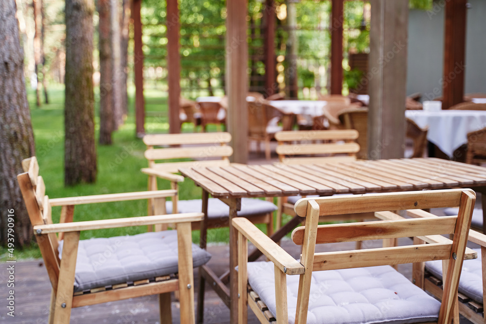 Outdoor cafe, patio wooden furniture.
