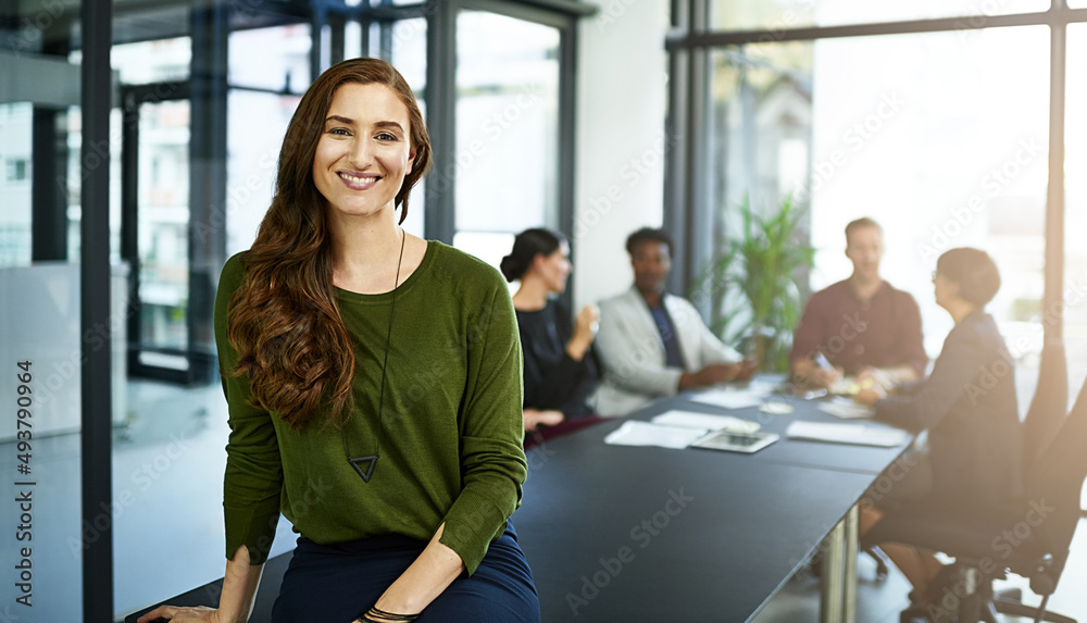 She the top dog at her company. Portrait of a businesswoman in a boardroom with her colleagues blurred out in the background. She the top dog at her company. Portrait of a businesswoman in a boardroom with her colleagues blurred out in the background.