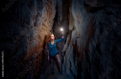 Obraz na plátne Young woman exploring a cave digged in the mountain.