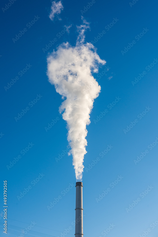 chimney of a Coal-fired power plant is blowing a ton of steam and Greenhouse gas into the blue sky. chimney of a Coal-fired power plant is blowing a ton of steam and Greenhouse gas into the blue sky.