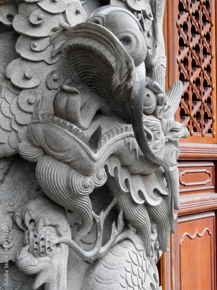 Ngong Ping, Hong Kong, China - September 17 2019: Po Lin monastery stone dragon carved pilar. Dragons in Chinese culture symbolize great power, good luck and strength