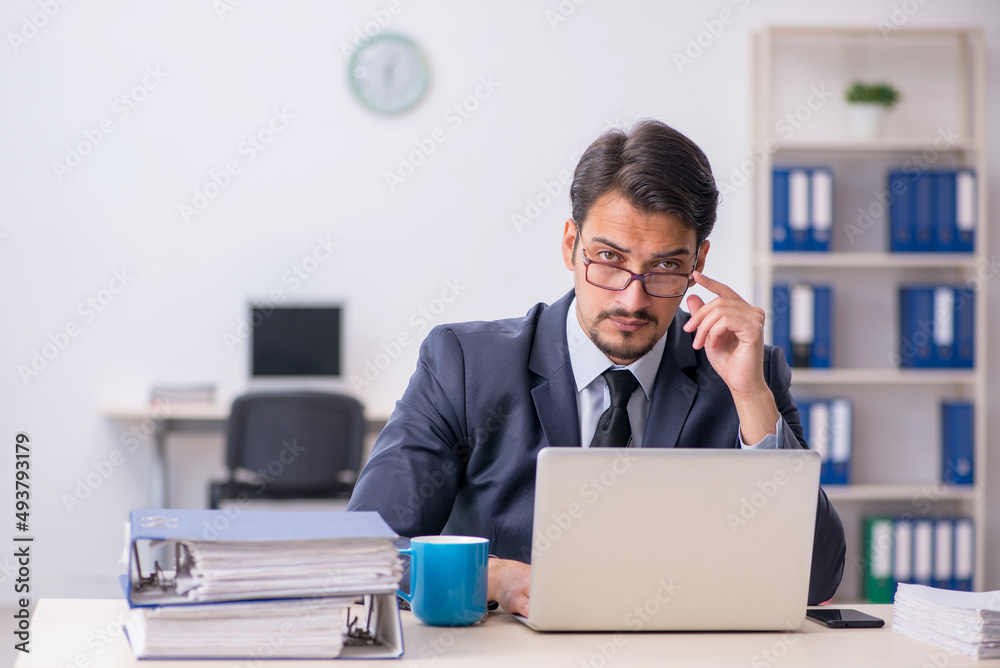 Young male employee sitting at workplace Young male employee sitting at workplace