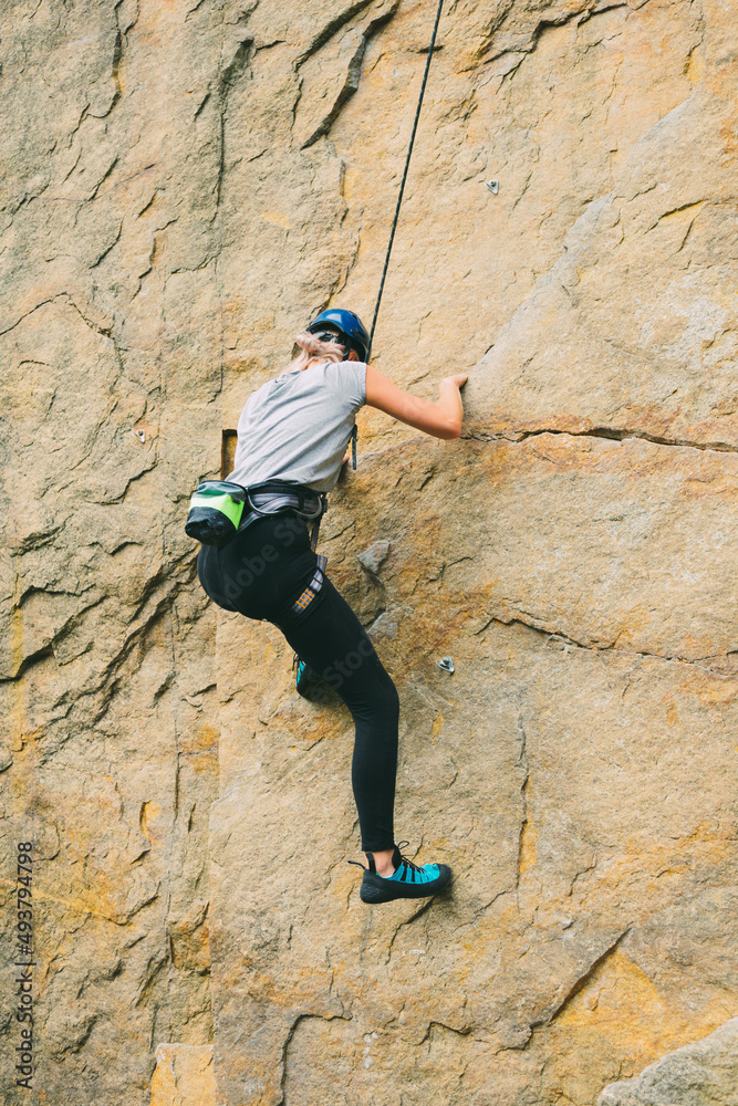 Young athletic woman in equipment doing rock climbing outdoors. Training area for outdoor activities. Extreme sport. Young athletic woman in equipment doing rock climbing outdoors. Training area for outdoor activities. Extreme sport.