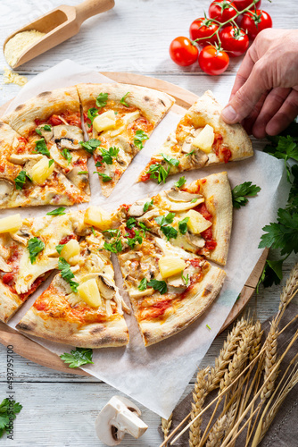 Overhead view of chicken and pineapple pizza sliced food