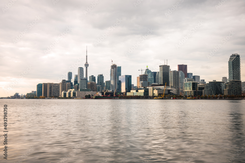 View of Toronto skyline under cloudy sky at sunset in autumn