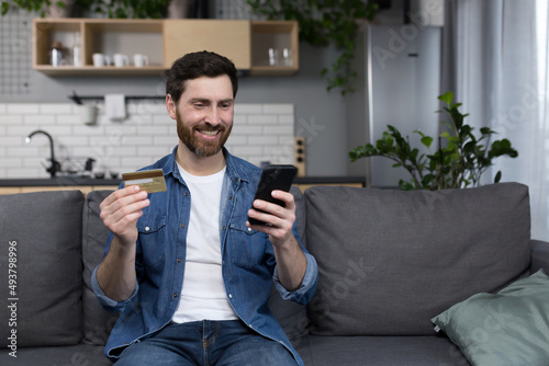 Freelancer at home performs banking operations, uses a banking application on a mobile phone, and a credit bank card photo