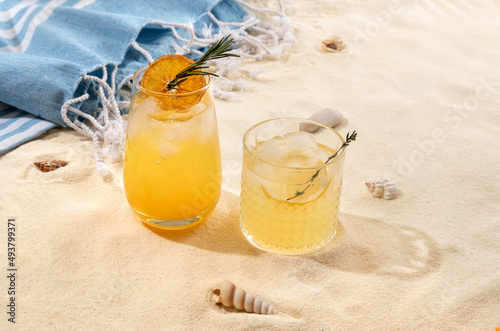 Fototapeta Naklejka Na Ścianę i Meble -  Selection of summer alcoholic cocktails on a wicker tray on beach with white sand. Summer sea vacation and travel concept. Exotic summer drinks.
