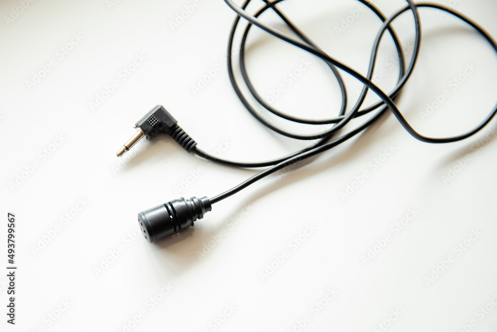 Radio microphone buttonhole on a light background.  Equipment for reporting and videography.