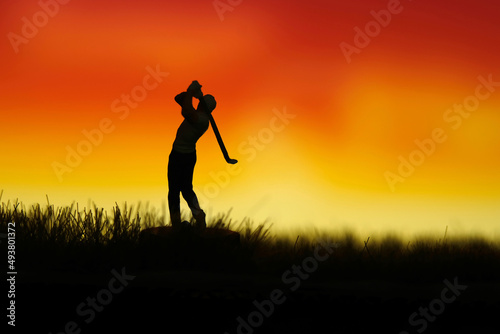 Miniature people toy figure photography. Silhouette of men golfer swing his stick at meadow field hill when sunset sunrise