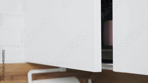 Soft close hinges on door of kitchen cabinets at home. Special mechanism designed to smoothly close doors. Modern kitchen equipment close view photo