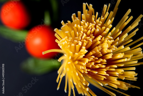 Spaghetti paste  tomato and other products for cooking on dark background top view. Space for text  top view