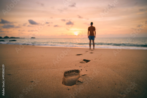 фотографія Footprints in sand against silhouette of person