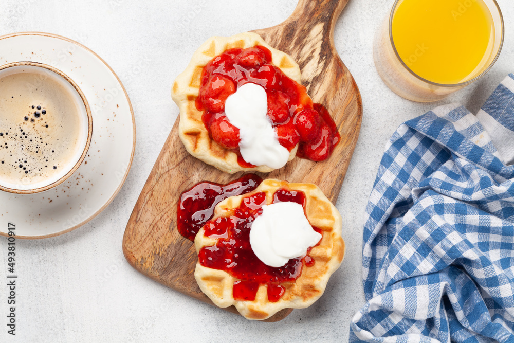 Fresh breakfast waffles with berry jam, coffee and orange Fresh breakfast waffles with berry jam, coffee and orange
