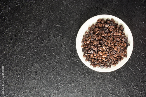 roasted coffee grains on black texture background © ismailyurtozveri