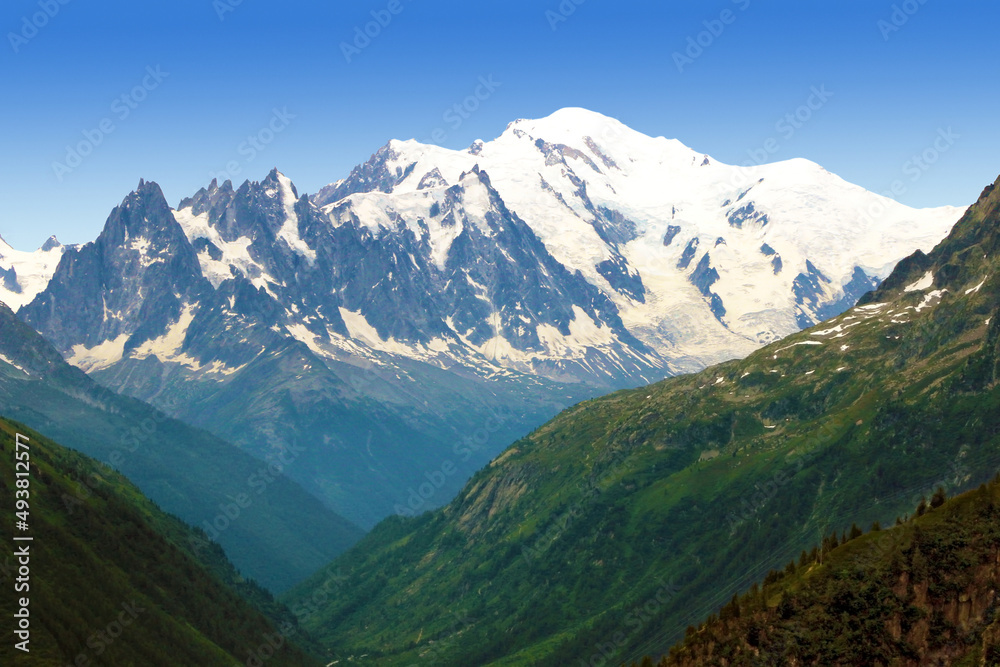 Le massif du Mont Blanc au dessus d'une vallée dans les Alpes.