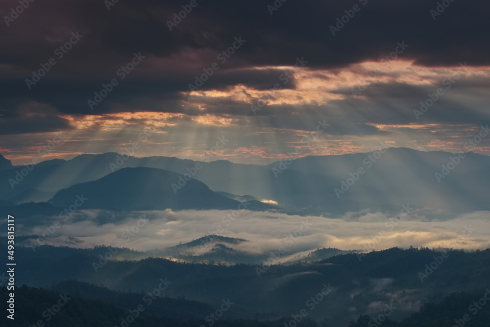 Beautiful sunlight ray over a mountain range and sea of fog in a valley