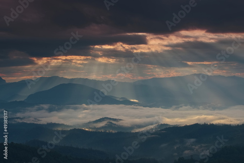 Beautiful sunlight ray over a mountain range and sea of fog in a valley