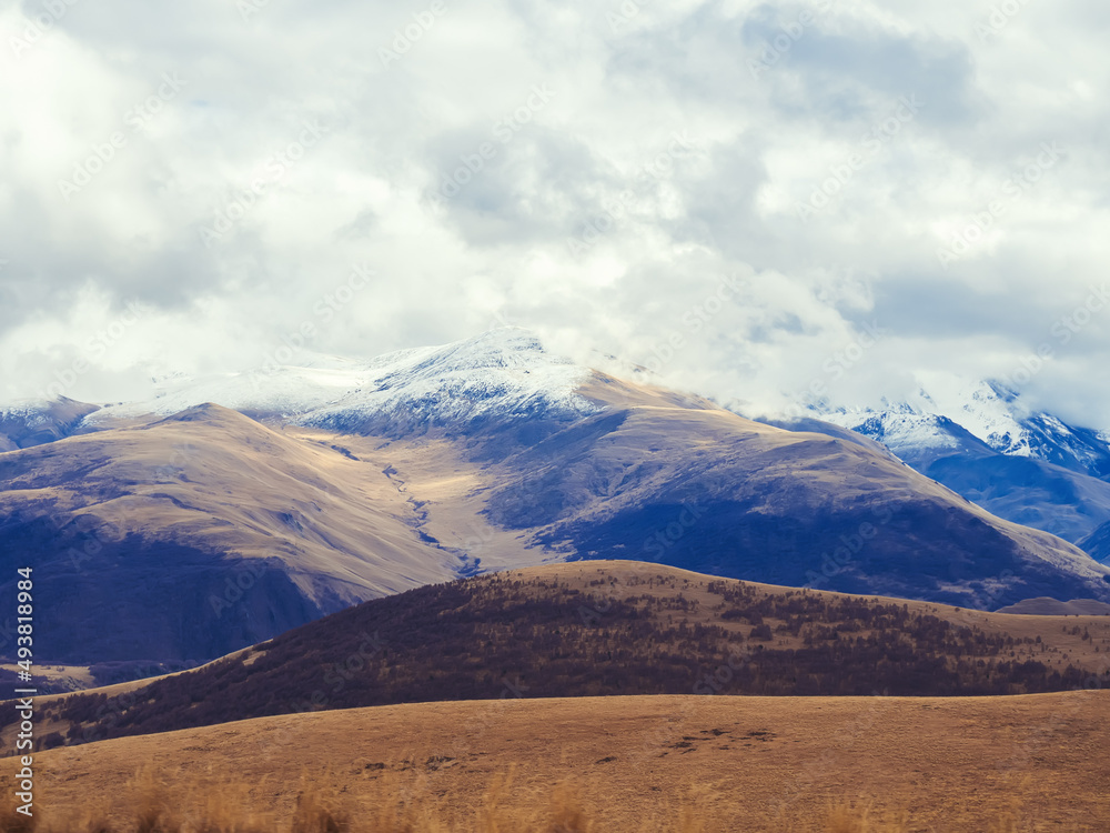Autumn Caucasian highlands with peaks sprinkled with snow and covered clouds. A sharp temperature drop in the highlands. Autumn Caucasian highlands with peaks sprinkled with snow and covered clouds. A sharp temperature drop in the highlands.