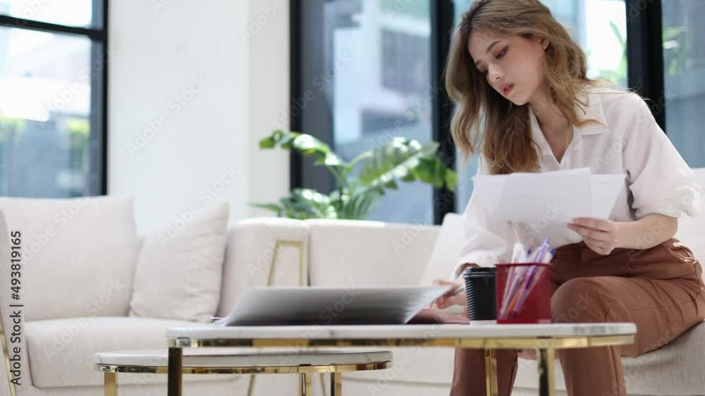 Beautiful young asian woman sitting at living room feeling stressed calculating monthly home expenses, taxes, bank account balance and credit card bills payment, manage budget, accountancy concept. Beautiful young asian woman sitting at living room feeling stressed calculating monthly home expenses, taxes, bank account balance and credit card bills payment, manage budget, accountancy concept.