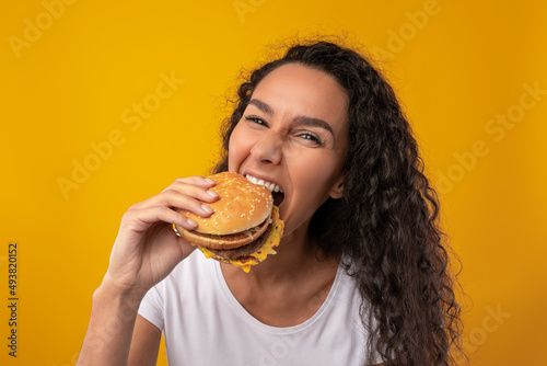 Funny Latin Lady Holding Burger Biting Sandwich At Studio