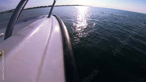 Seascape, view of sea waves with sun reflection from prow of motorboat. Boat jumping on waves on sunny summer day. Yacht motor boat sailing fast at sea horizon. Extreme sport entertainment background