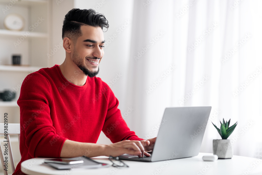 Handsome Arab Male Freelancer Working On Laptop At Home Office Handsome Arab Male Freelancer Working On Laptop At Home Office