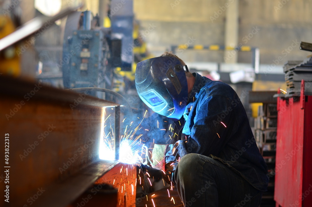 A welder works at a factory A welder works at a factory