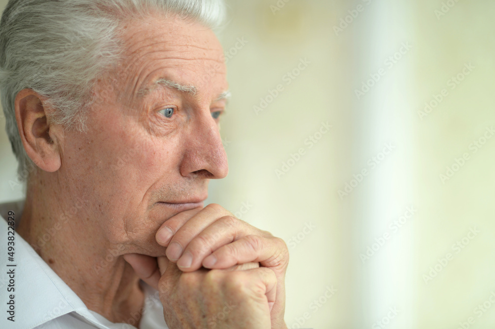 Beautiful sad thinking senior man posing at home Beautiful sad thinking senior man posing at home