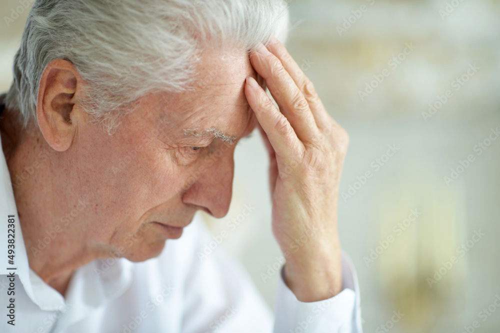 Beautiful sad thinking senior man posing at home Beautiful sad thinking senior man posing at home