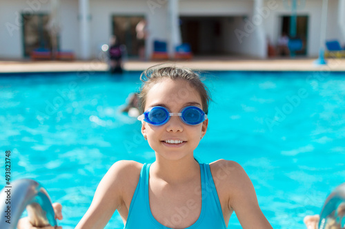 Portrait of a teenager girl in swimming pool during summer vacation.
