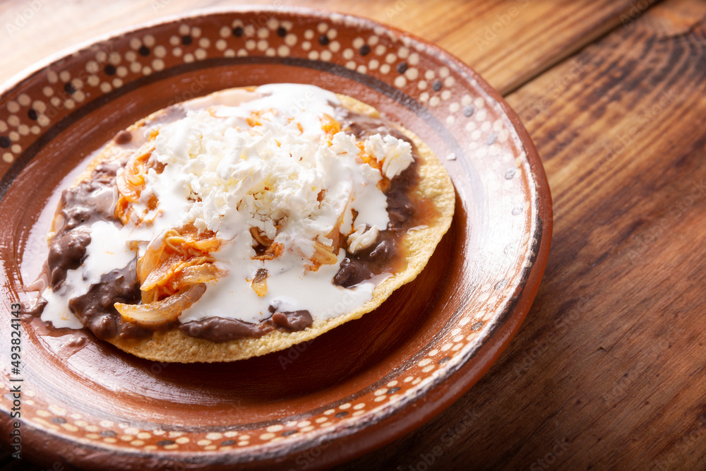 Tostadas de Tinga de Pollo. Traditional mexican homemade chicken toasts with beans, chicken breast meat, onion and chipotle chili topped with sour cream and fresh white cheese Tostadas de Tinga de Pollo. Traditional mexican homemade chicken toasts with beans, chicken breast meat, onion and chipotle chili topped with sour cream and fresh white cheese