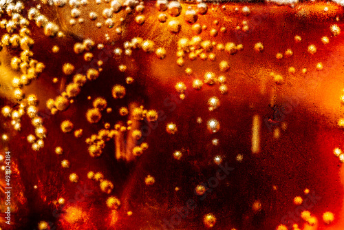 macro soft drink texture,Soft drink glass with ice splash on dark background. Cola glass in celebration party concept.