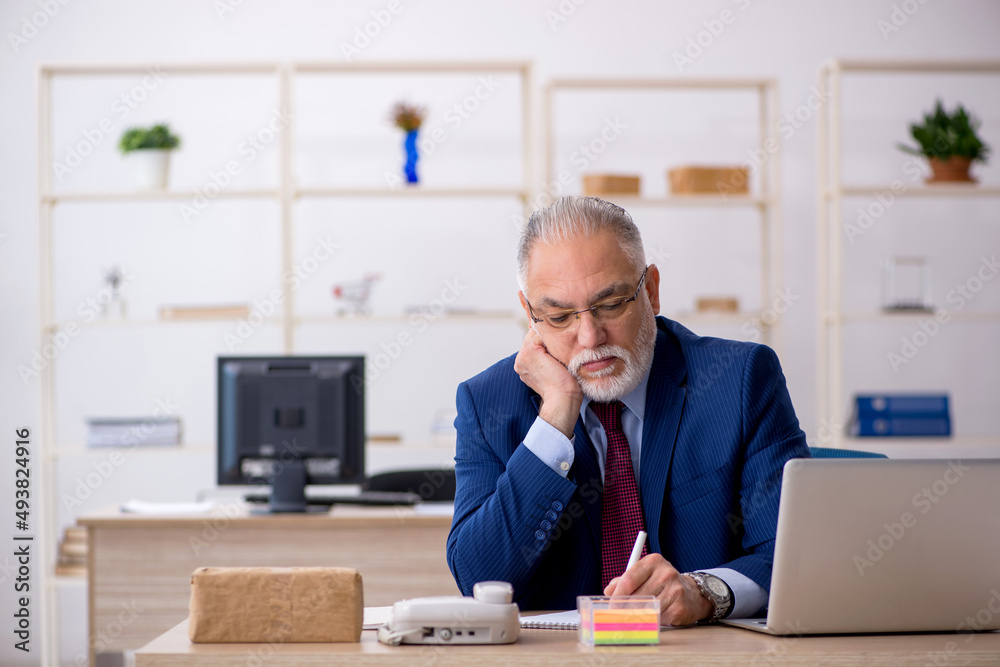 Old male employee working in the office Old male employee working in the office