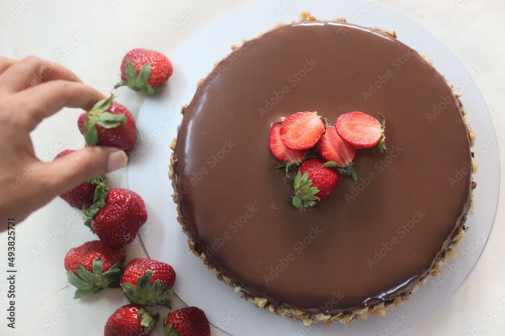 Chocolate cake with chocolate ganache and topped with walnut and fresh strawberries Chocolate cake with chocolate ganache and topped with walnut and fresh strawberries