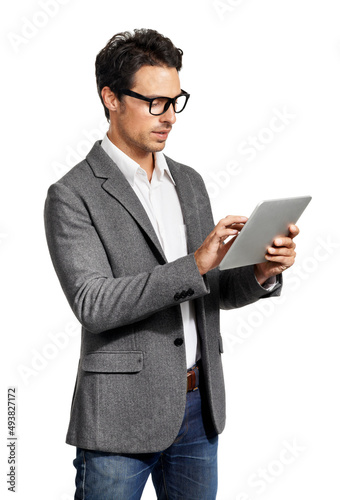 Obraz na płótnie Working using tablet technology. A handsome young man working on his tablet.