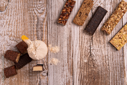 Fototapeta Naklejka Na Ścianę i Meble -  protein bar and granola bars on a wooden table top view. The concept of healthy sweets