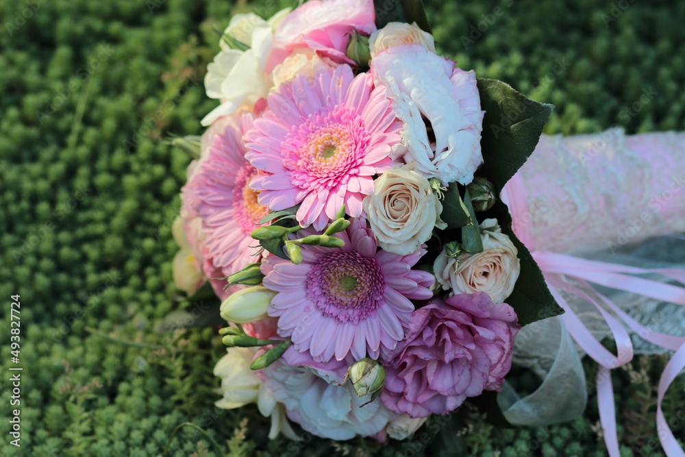 wedding bouquet consists of white, pink, purple flowers, green leaves, gerbera flowers, peony roses on stonecrop or sedum background, colourful flowers viewed from high angle on green grass background wedding bouquet consists of white, pink, purple flowers, green leaves, gerbera flowers, peony roses on stonecrop or sedum background, colourful flowers viewed from high angle on green grass background