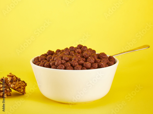 Chocolate Corn balls in bowl over yellow background