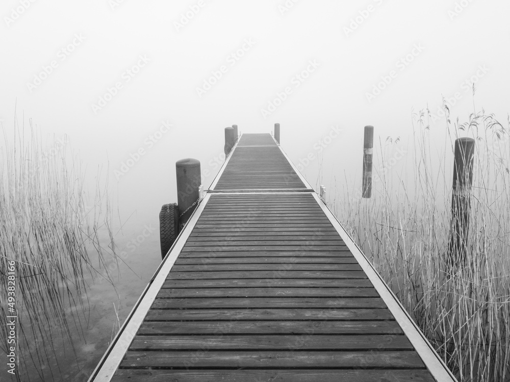 The jetty on the foggy lake, in shades of grey The jetty on the foggy lake, in shades of grey